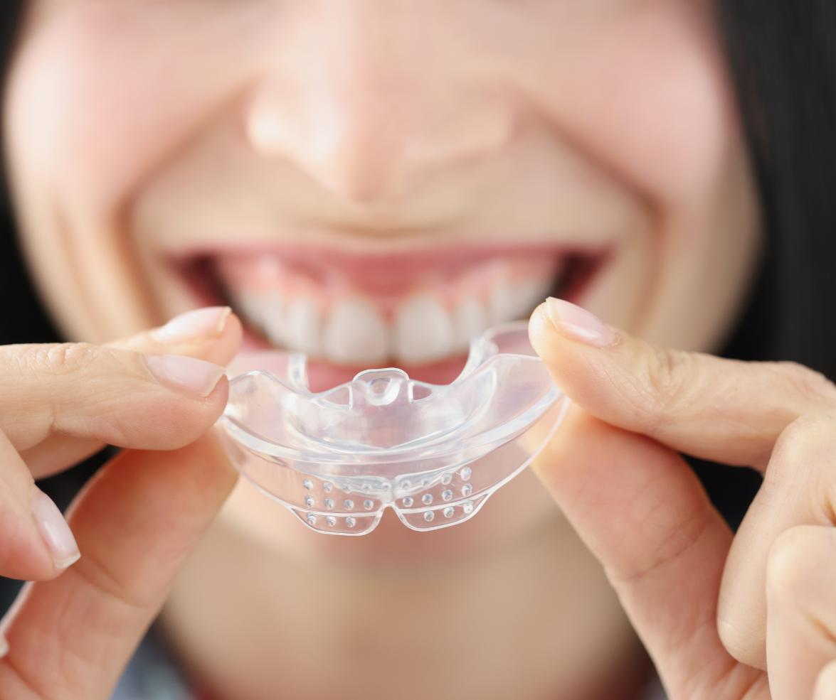 A patient wearing a special sleep apnea oral appliance custom fit by our dentist in Midlothian